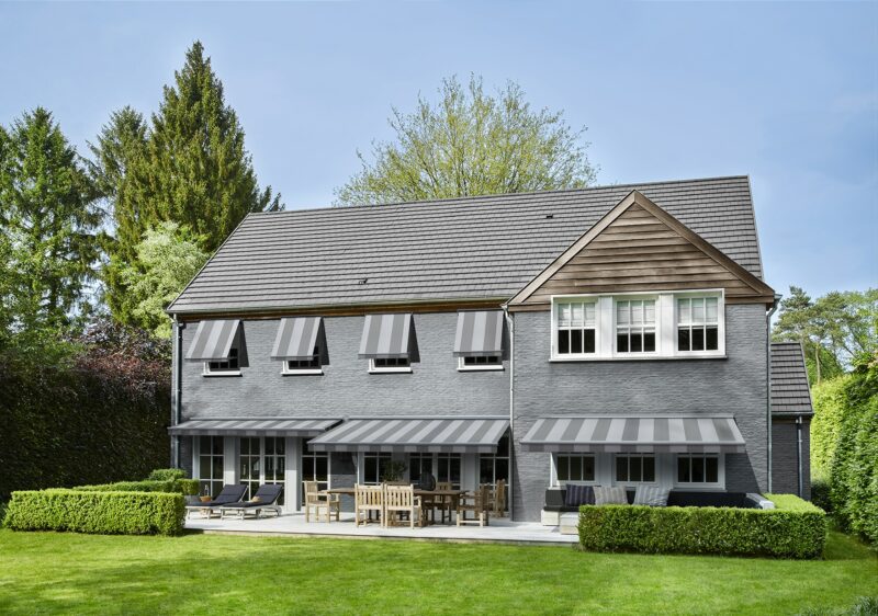 grande maison avec stores bannes et stores à l'italienne rayures grises et blanches