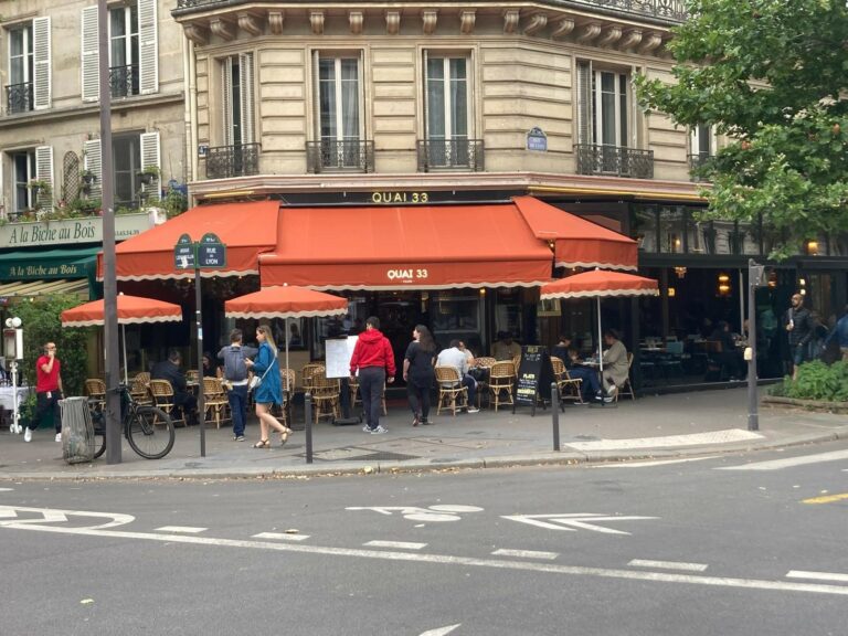 parasols ronds couleur brique devant store et capotes restaurant quai 33 Paris