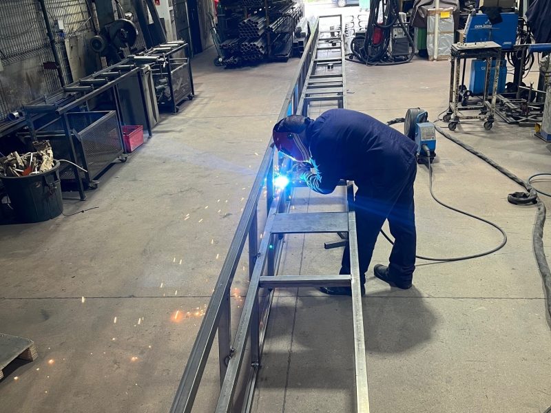 employé en rain de souder dans l'atelier de serrurerie Dupont Kine