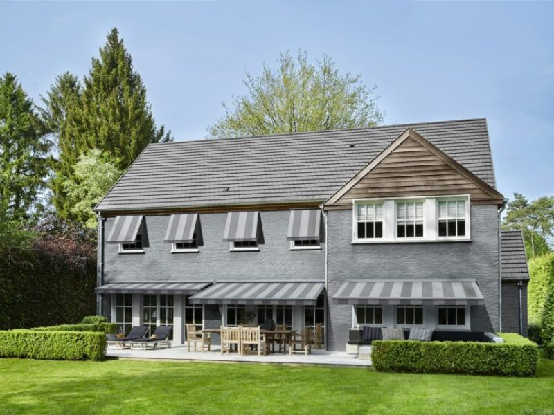 grande maison avec stores bannes et stores à l'italienne rayures grises et blanches